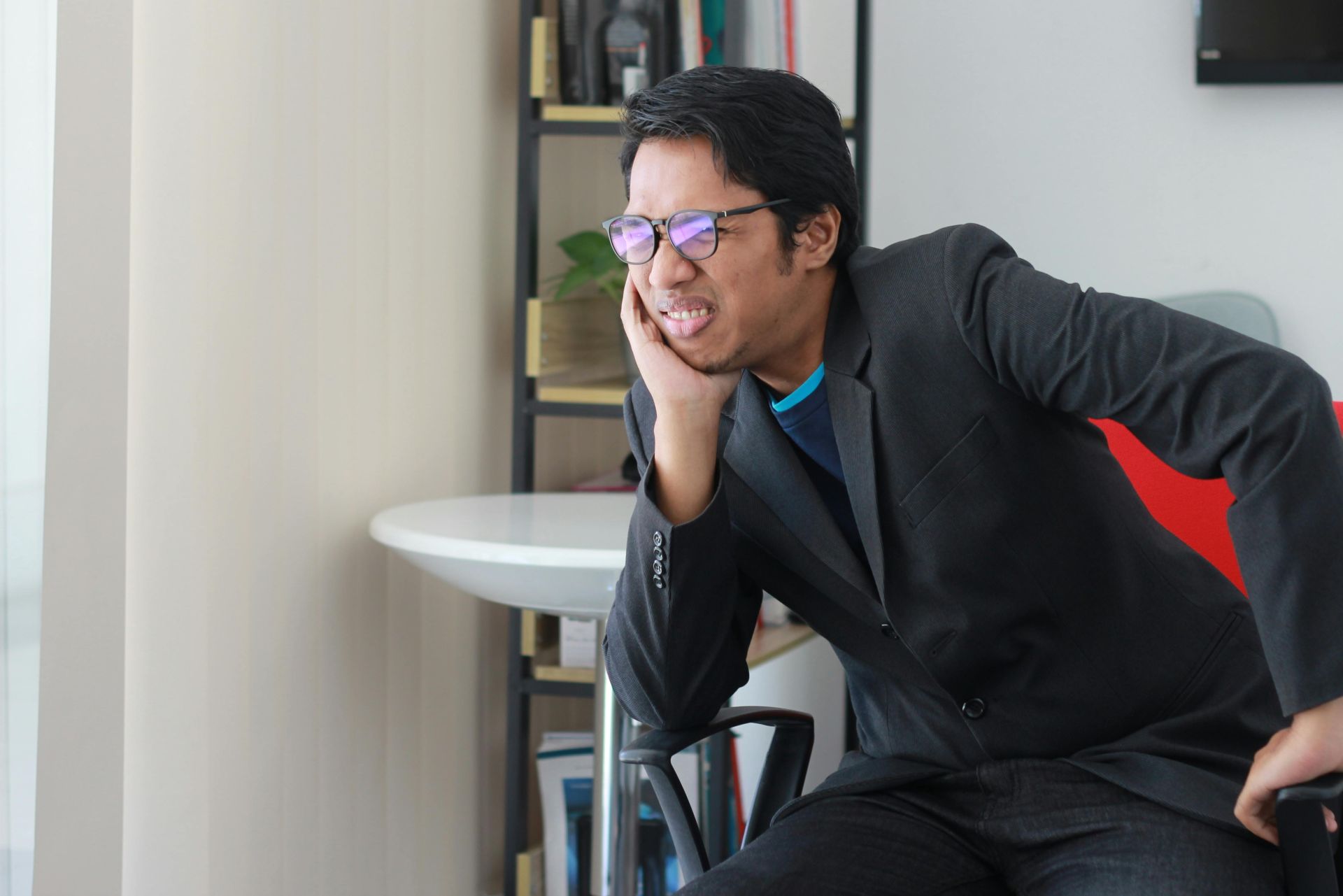 A Man in Black Suit Sitting inside the Office